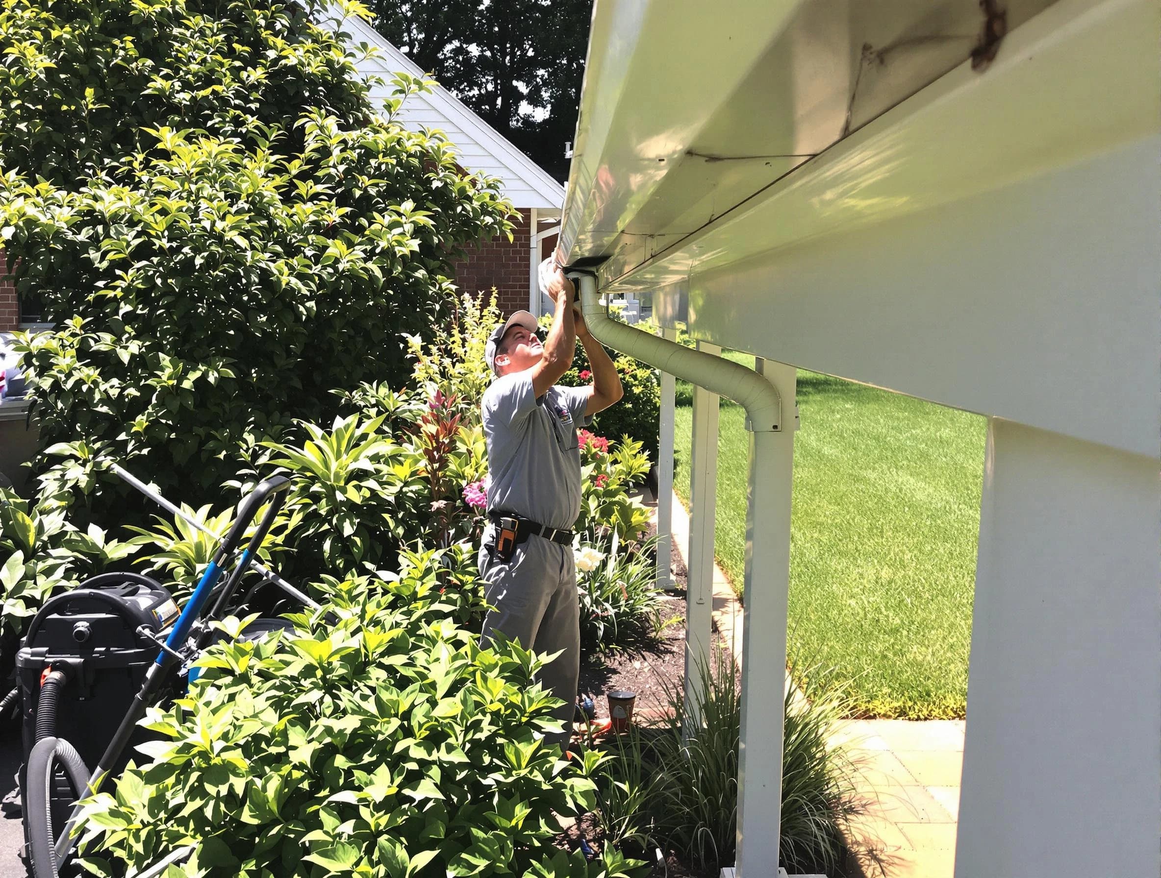 Technician flushing a blockage from a downspout in North Royalton, OH